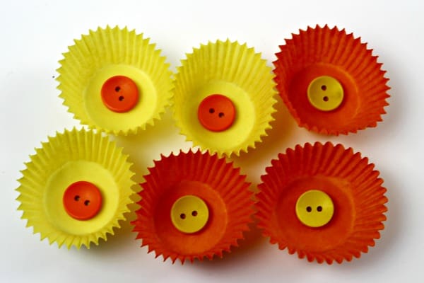 3 Orange cake cases with buttons in the center and 3 yellow ones with buttons in the center to make daffodil flower petal