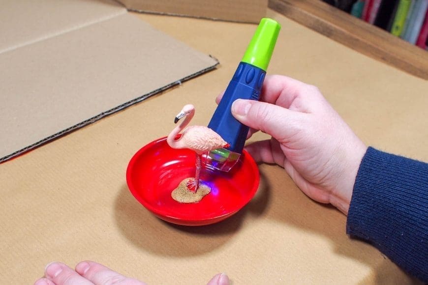 A red bowl with a pink plastic flamingo glued in the center