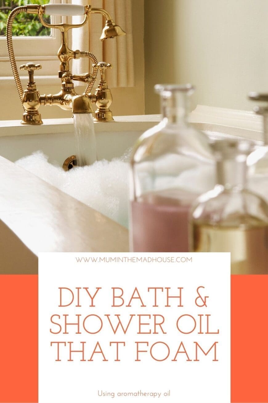A foaming bubble bath with gold taps and bath oil on the side