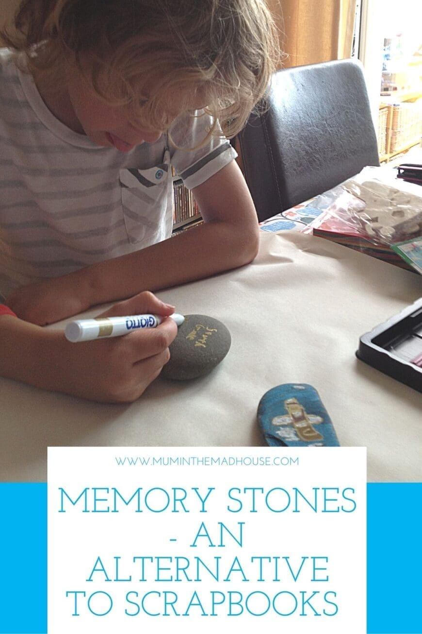Boy sat writing on a rock with a pen