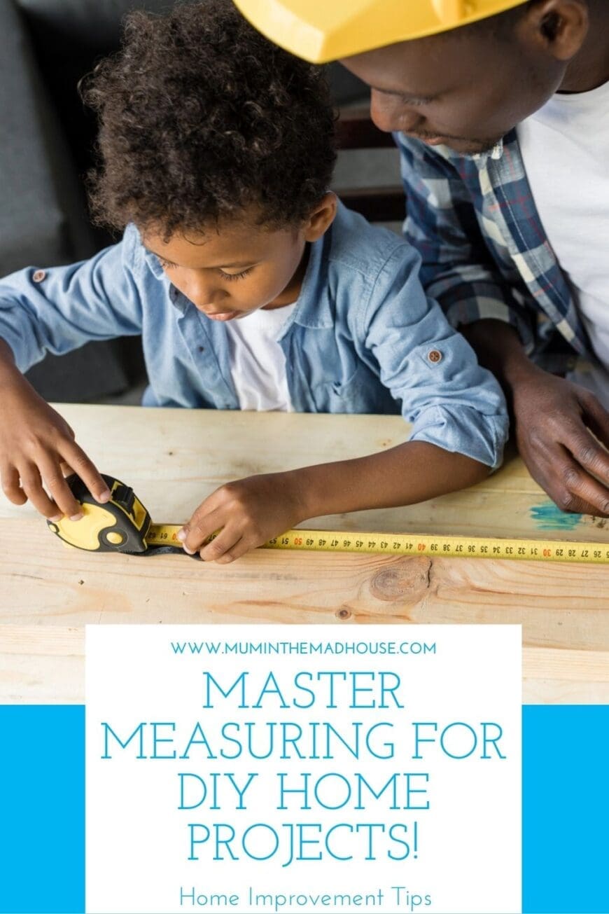 A young child carefully measures a wooden plank using a yellow tape measure, with an adult wearing a yellow hard hat guiding them. The scene captures a hands-on DIY home improvement moment, emphasizing learning and precision