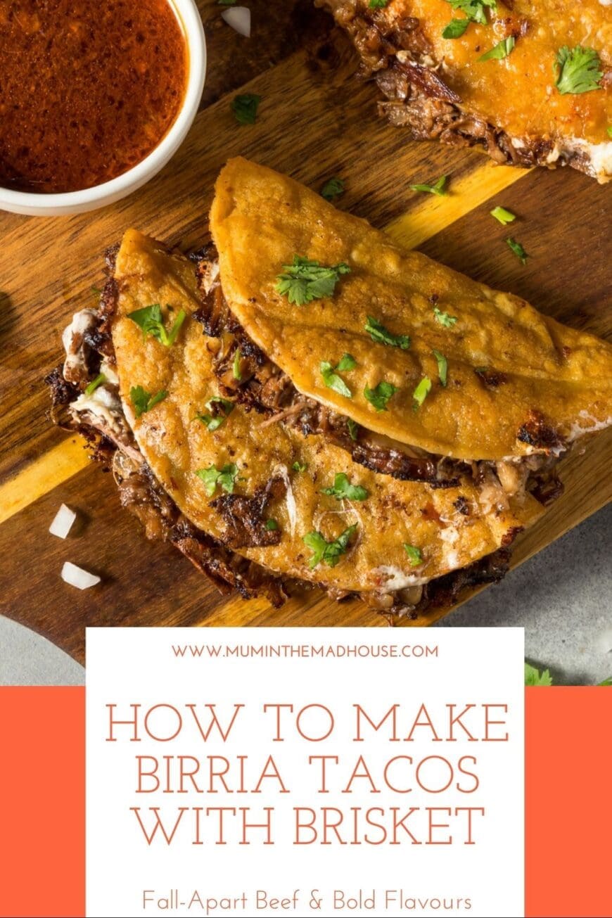 Overhead view of golden birria tacos made with shredded brisket, topped with chopped coriander, served on a wooden board with a bowl of rich red dipping consomé.